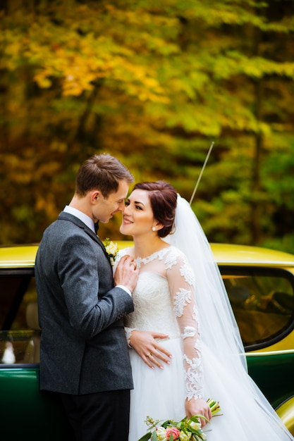 Junges schönes Hochzeitspaar am Wald