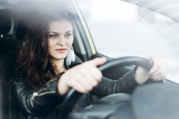 Junges schönes Mädchen, das ein Auto antreibt