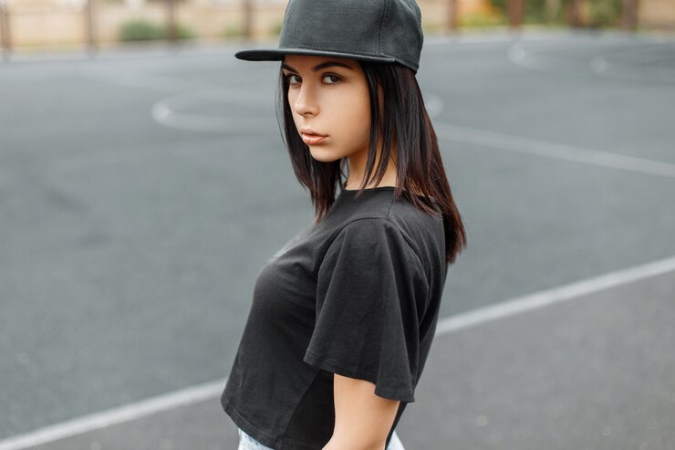 Foto junges schönes mädchen in einer schwarzen baseballkappe und t-shirt das stadion.