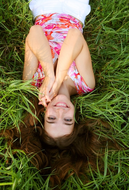 Junges schönes Mädchen legt auf ein Gras