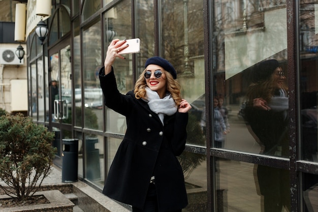 Junges schönes Mädchen macht ein Selfie auf der Straße