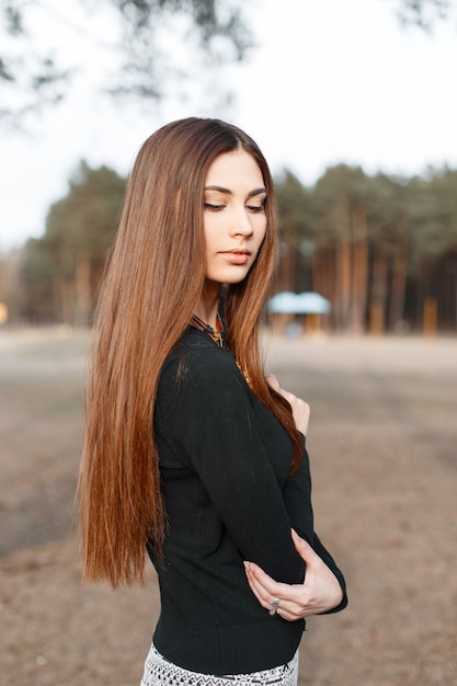 Junges schönes Mädchen mit langen Haaren im schwarzen Hemd