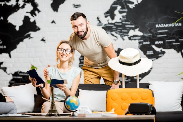 Foto junges schönes paar sitzt im reisebüro und bereitet sich auf einen sommerurlaub vor