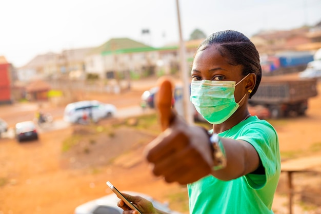 Junges schwarzafrikanisches Mädchen mit Gesichtsmaske, das die Ausbreitung des Corona-Virus verhindert. Influenza mit Gesichtsmaske zur Sensibilisierung für die Verwendung von Nasenmasken