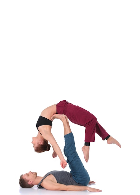 Junges sportliches Paar, das Acroyoga praktiziert, das paarweise balanciert
