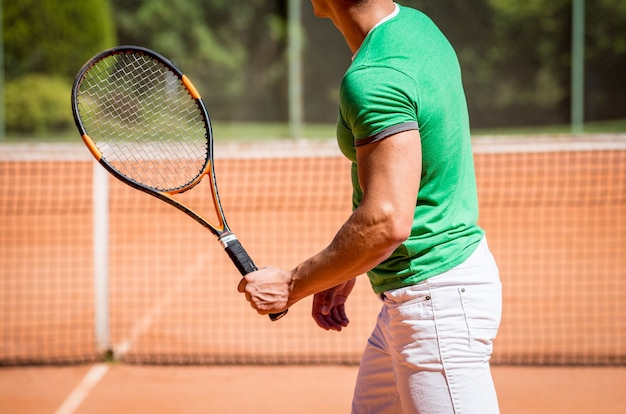 Junges sportliches Paar, das Tennis auf dem Platz spielt.