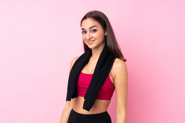 Junges Sportmädchen über lokalisiertem rosa Hintergrund mit Sporttuch