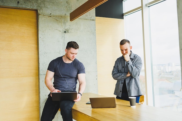 Junges Team von Kollegen, die im Büro zusammenarbeiten, hören dem Manager während eines Geschäftstreffens zu und arbeiten gemeinsam am Projektstart in einem modernen Konferenzraum