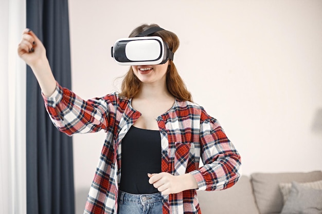 Foto junges teenager-mädchen, das im wohnzimmer steht und eine virtual-reality-brille trägt