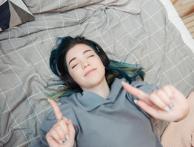 Junges Teenager-Mädchen mit blauen Haaren und Kopfhörern