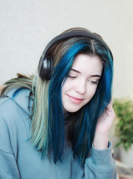 Junges Teenager-Mädchen mit blauen Haaren und Kopfhörern