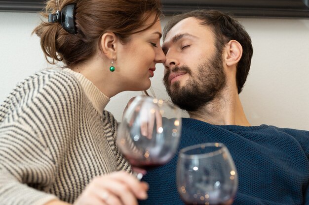 Junges und glückliches Paar, das Wein trinkt und sich zu Hause entspannt