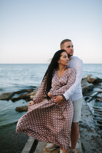 Junges verliebtes Paar Attraktiver Mann und Frau genießen einen romantischen Abend am Strand und beobachten den Sonnenuntergang