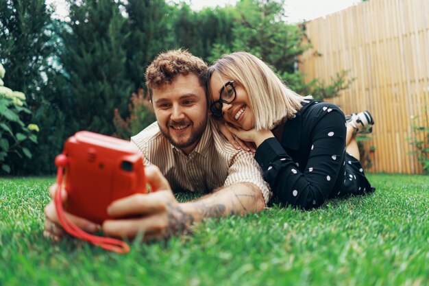 Junges verliebtes Paar, das ein Selfie mit einer Sofortbildkamera nimmt