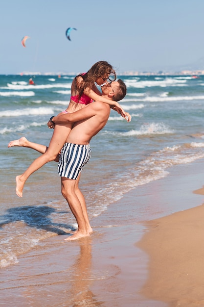 Junges verliebtes Paar, das romantische zarte Momente am Strand hat.