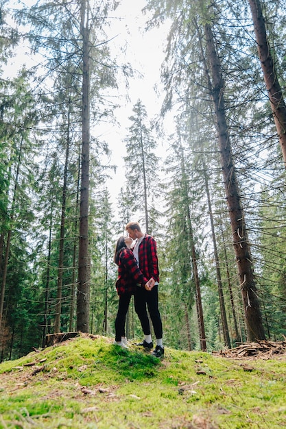 Junges verliebtes Paar umarmt und küsst sich im Wald