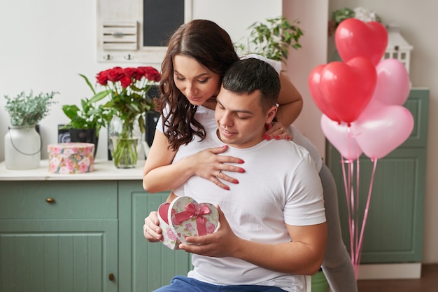 Junges verliebtes Paar zu Hause, das Valentinstag feiert