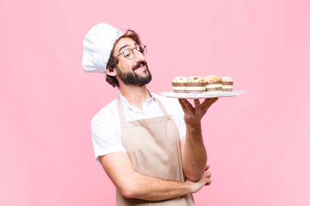 Junges verrücktes Bäcker-Mann-Süßwarenkonzept gegen rosa Wand