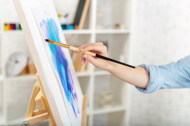 Junges weibliches Künstlermalereibild im Studio