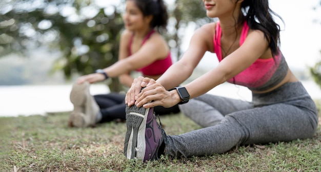 Junges weibliches Training vor dem Fitnesstraining im Park Gesunde junge Frau, die sich im Freien aufwärmt