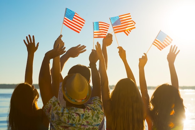 Jungs und Mädchen, die amerikanische Flaggen schwenken.