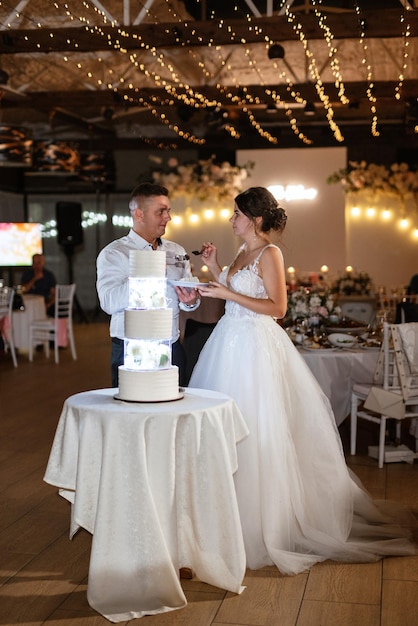 Foto jungvermählte schneiden und schmecken glücklich den hochzeitskuchen