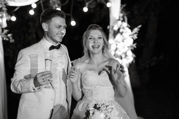 Jungvermählten schneiden glücklich lachen und probieren die Hochzeitstorte