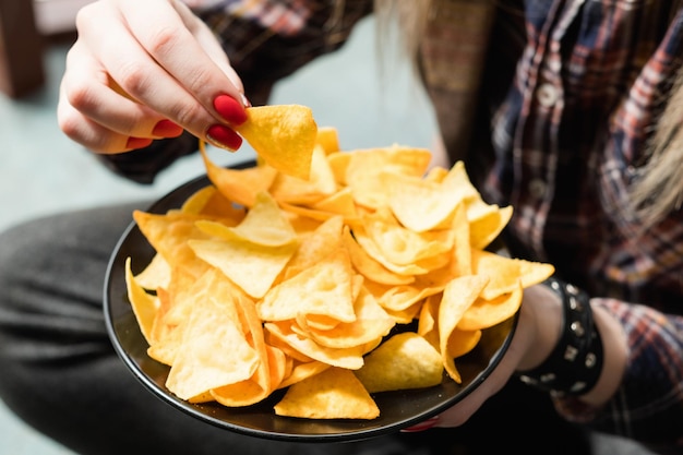 Junk-Fast-Food und ungesunde Ernährung Frau isst Chips aus einer Schüssel knuspriger Chips