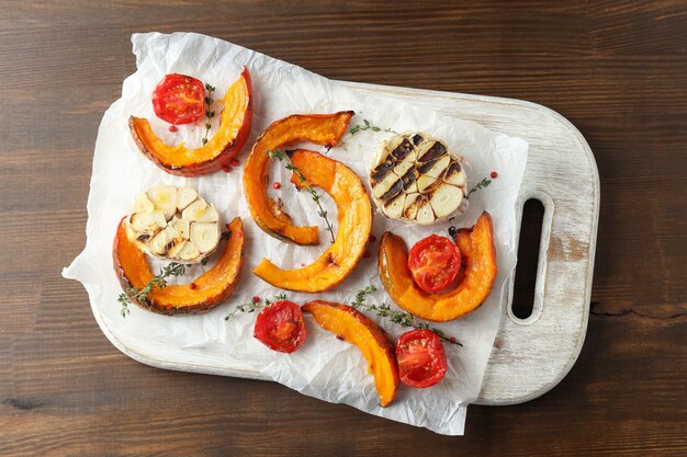 Junta con calabaza al horno y especias sobre fondo de madera.