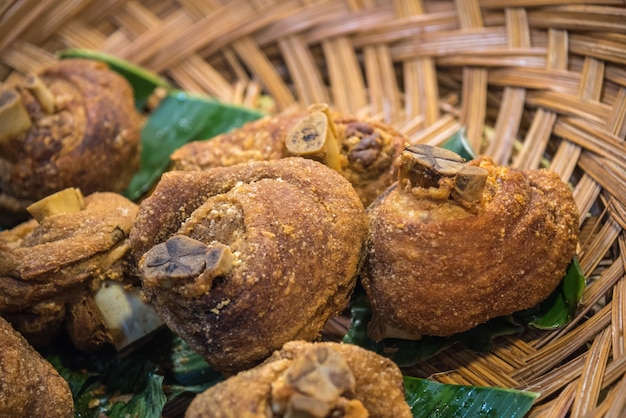 Foto junta de carne de porco crocante (crocante fried pork leg) na cesta tradicional tailandesa na folha de bananeira