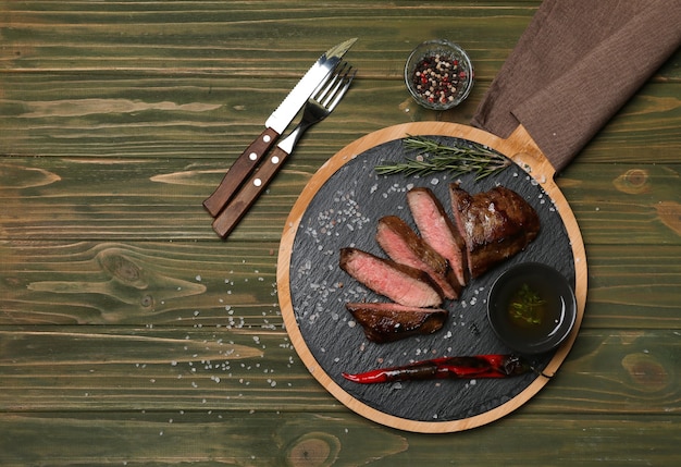 Junta con sabrosa carne cocida en mesa de madera