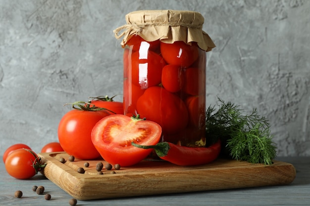 Junta con tarro de tomates en escabeche sobre mesa de madera