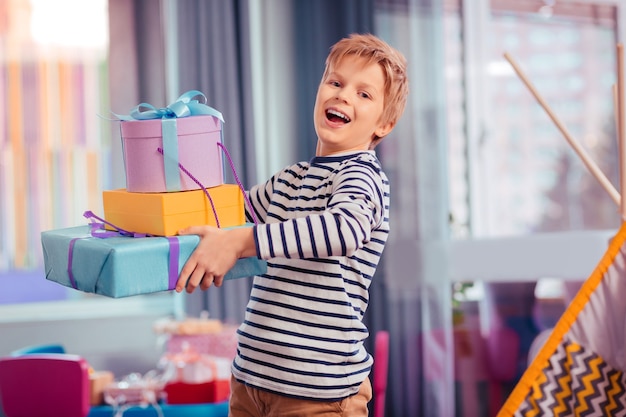 Junte-se a mim. criança alegre e loira se sentindo feliz durante a festa de aniversário