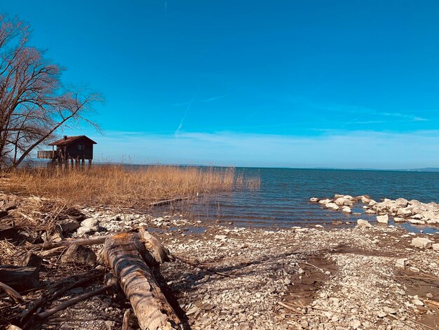 Junto al lago con una casa y un cielo azul de fondo