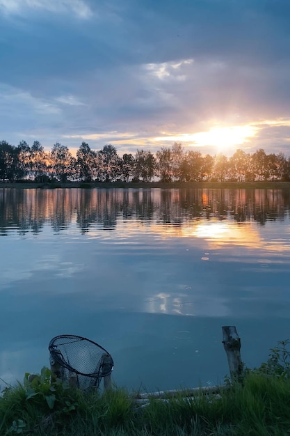 Junto al lago por la noche al atardecer pescando