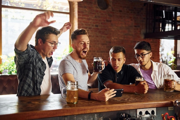 Junto a la mesa Gente con ropa informal sentada en el pub