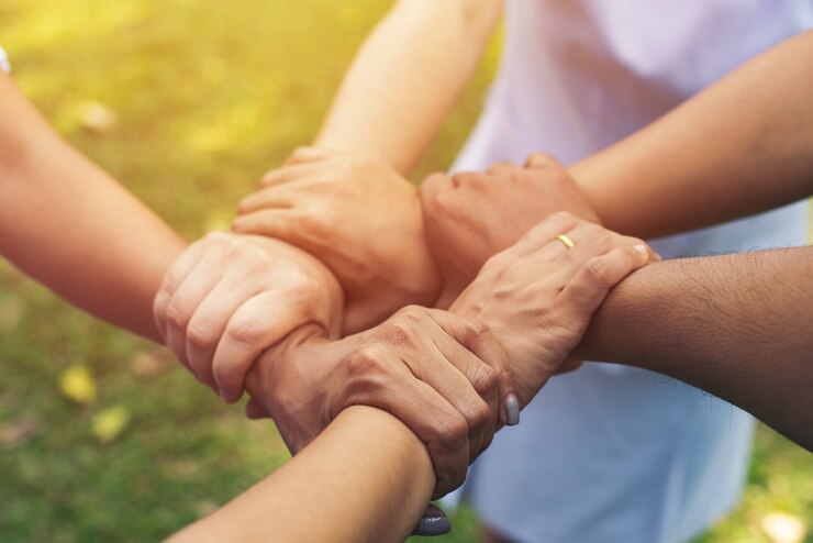 Juntos colaboram no trabalho em equipe de mãos no parque ao ar livre. Conceito de caridade de trabalho em equipe, grupo de mãos diversas, processamento cruzado de pessoas na natureza