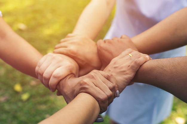 Juntos colaboran en el trabajo en equipo de manos en el parque al aire libre. Concepto de caridad de trabajo en equipo, grupo de diversas manos juntas procesamiento cruzado de personas en la naturaleza