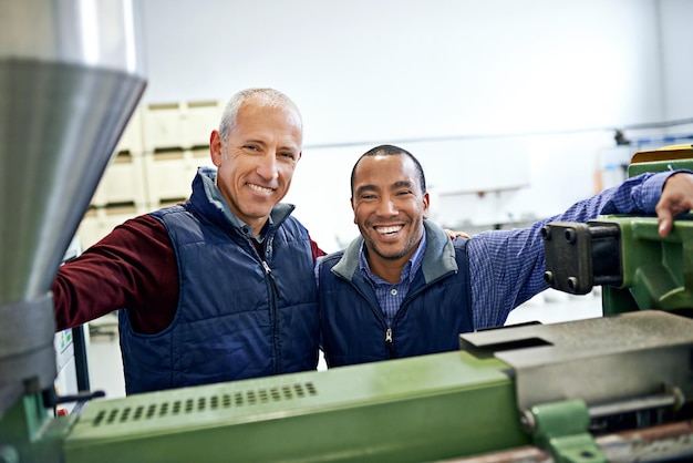 Juntos, fazemos esta máquina funcionar sem problemas Foto de dois homens trabalhando em máquinas de fábrica