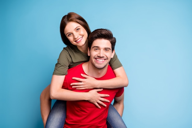 Juntos para siempre. Retrato de pareja romántica positiva hombre abrazo a cuestas a su mujer amada el 14 de febrero ropa de estilo casual ropa de estilo informal aislado sobre fondo de color azul