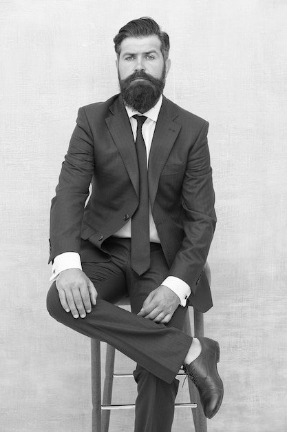Justiça e justiça Elegante e formal Homem barbudo usa terno formal Advogado elegante sentado na cadeira Reunião de negócios Evento formal Homem com barba e bigode advogado confiante Seu advogado