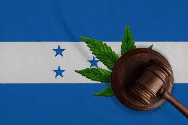 Justiça martelo de madeira com folha de cannabis na bandeira de Honduras Crescimento ilegal de planta de cannabis e drogas se espalhando