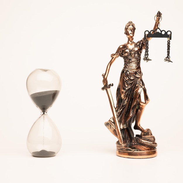 Justilia o Themis (símbolo de la justicia) estatua y reloj de arena aislado sobre fondo blanco con trazado de recorte