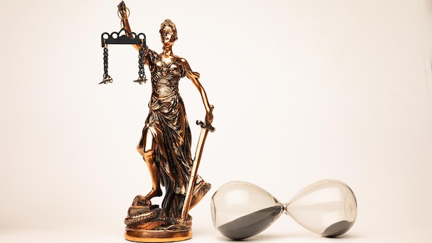 Justilia o Themis (símbolo de la justicia) estatua y reloj de arena aislado sobre fondo blanco con trazado de recorte