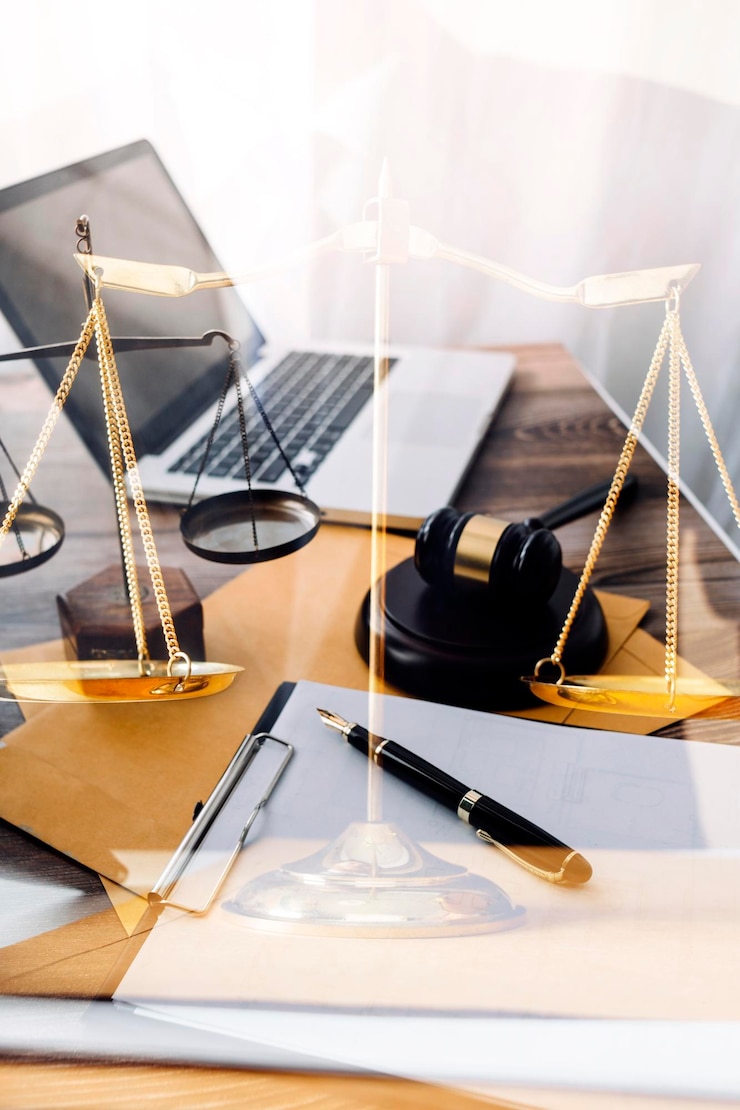 Foto justiz- und rechtskonzeptmännlicher richter in einem gerichtssaal mit dem hammer, der mit dem computer arbeitet und im morgenlicht eine tastaturbrille auf dem tisch andockt