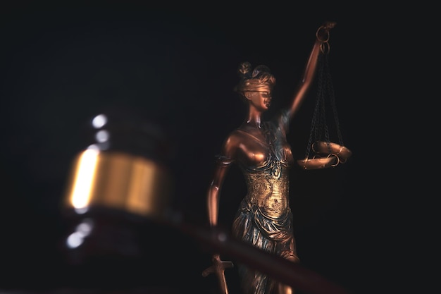 Justizkonzept Göttinnenwaage und Richterhammer auf einem Holztisch