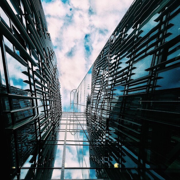 Foto justo debajo de la toma de un edificio moderno contra un cielo nublado