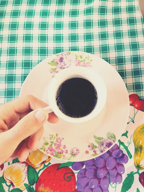 Foto justo por encima de la foto de la mano sosteniendo la taza de café