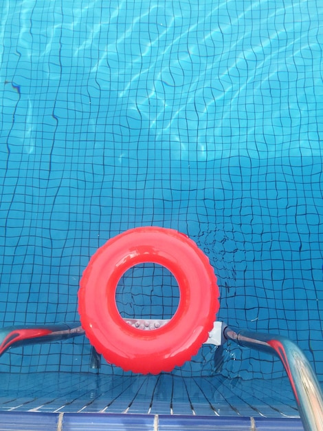 Justo por encima de la toma de un anillo inflable rojo en una piscina