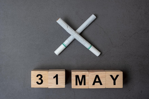 Justo por encima de la toma de los bloques de juguete de texto por los cigarrillos en fondo gris